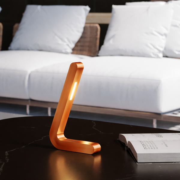 Copper finish L-shaped wooden lamp by WOOM with a bright light strip on a black marble table.