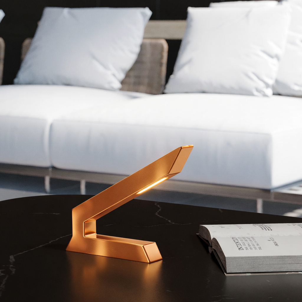 Copper finish angular table lamp by WOOM, with glowing light on a dark marble table next to an open book.