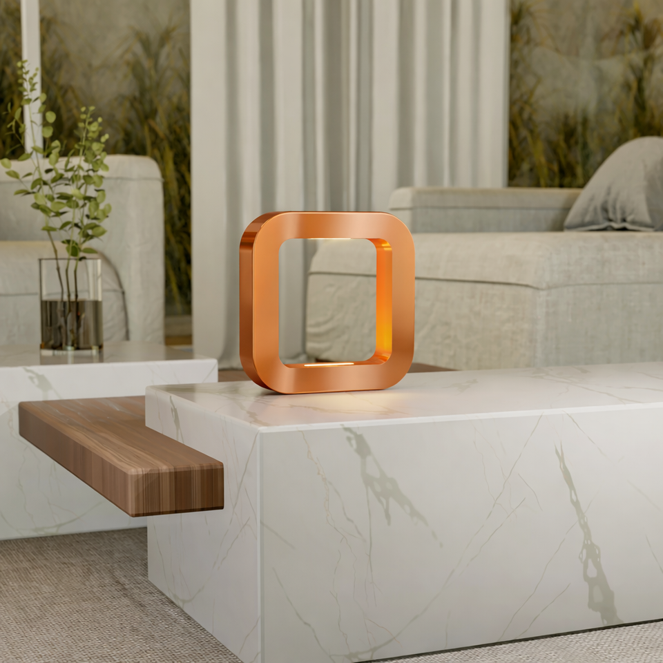 Rotatable square copper finish oak table lamp by WOOM with illuminated interior on a white marble coffee table.