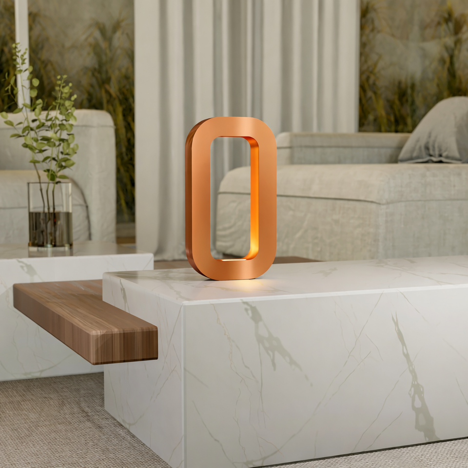 Copper finish wooden table lamp by WOOM, glowing orange, on a white marble table.