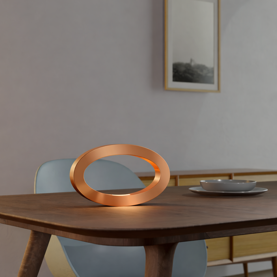 Copper Finish Handcrafted Rotatable Wooden Oval Lamp by WOOM, casting a warm glow on a wooden table.