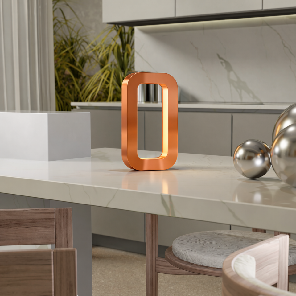 Copper finish rectangular oak table lamp by WOOM, glowing softly on a marble kitchen island with silver spheres.
