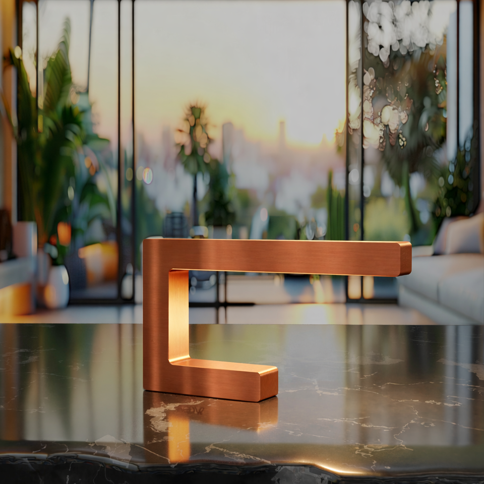 Copper finish C-shaped lamp by WOOM, emitting warm light on a dark marble surface in a modern interior.
