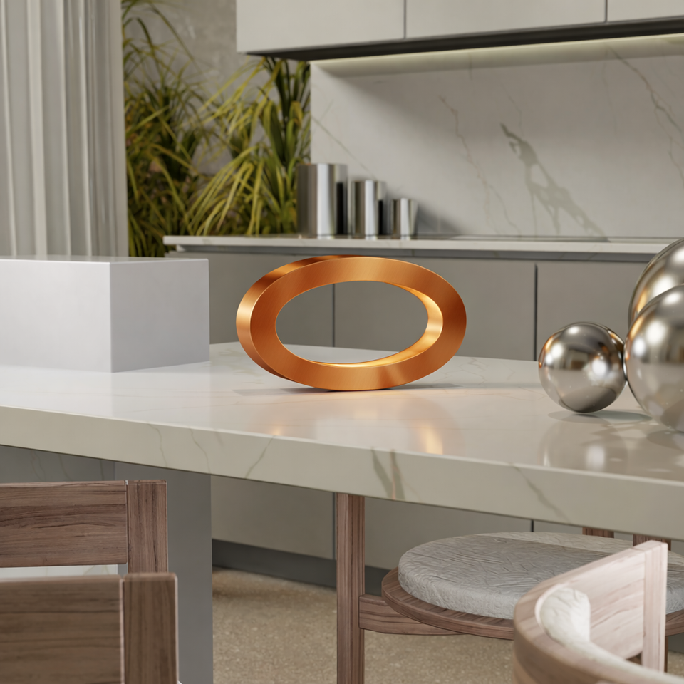 Smooth, reflective copper oval loop lamp by WOOM on a white marble kitchen counter.