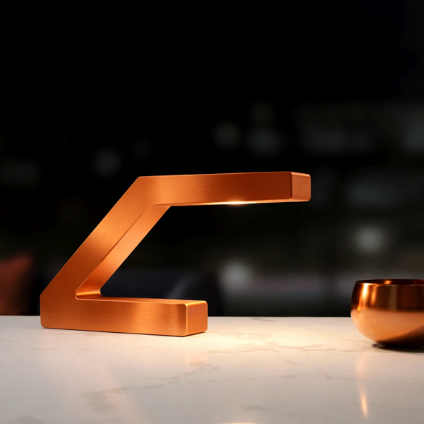 Copper finish handcrafted oak Z-shaped lamp by WOOM, illuminating a white marble surface next to a copper bowl.