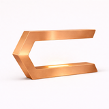 C-shaped LED table lamp in a brushed copper finish by WOOM, with an illuminated strip inside the lower arm.