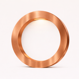 Copper finish round table lamp by WOOM, with warm light glowing from its brushed metallic frame onto a white interior.
