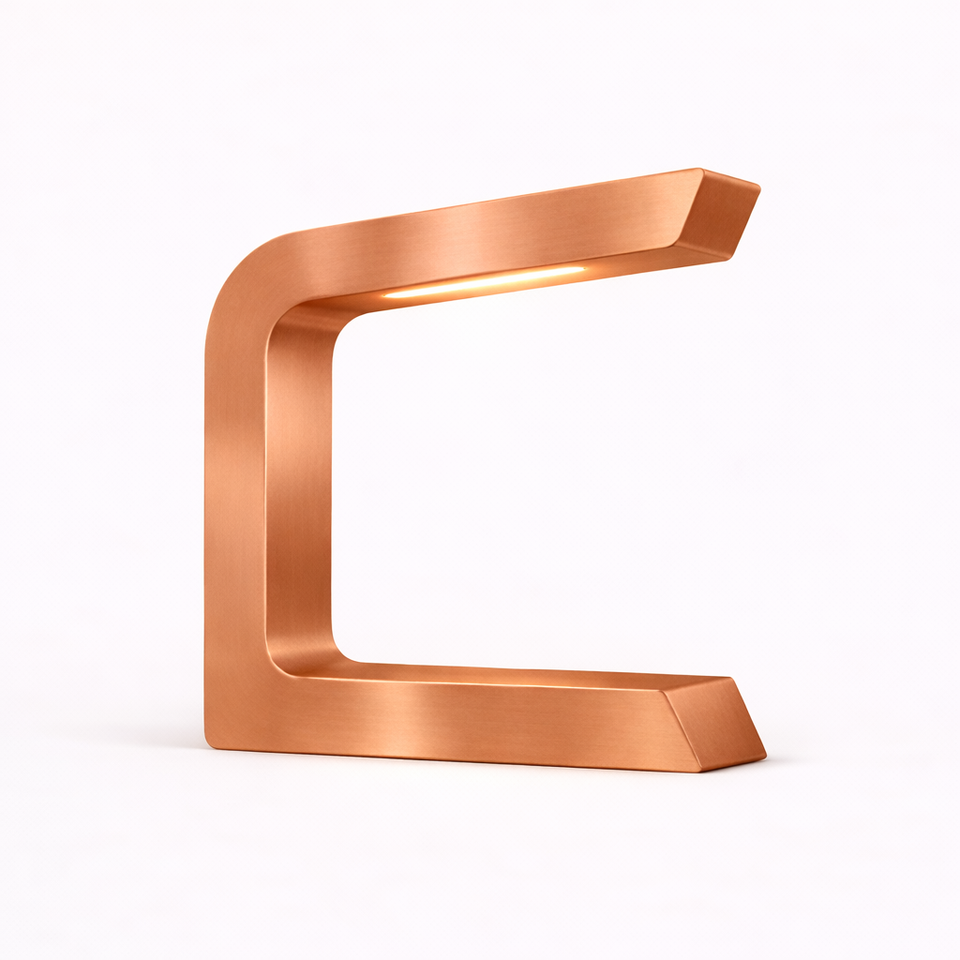 Copper finish C-shaped lamp by WOOM with a brushed metallic texture and warm internal light.