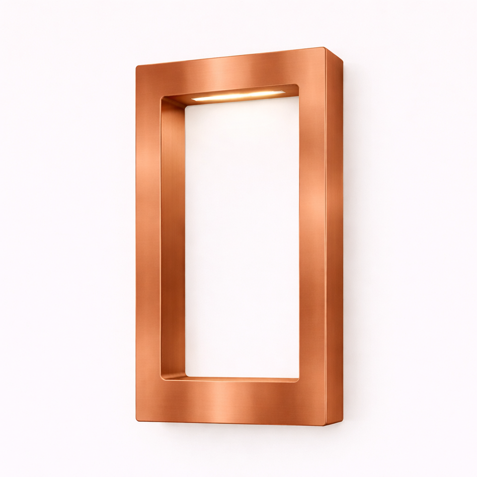 Rectangular wooden lamp with a brushed copper finish by WOOM, mounted on a white wall with a warm light glowing from its top interior.