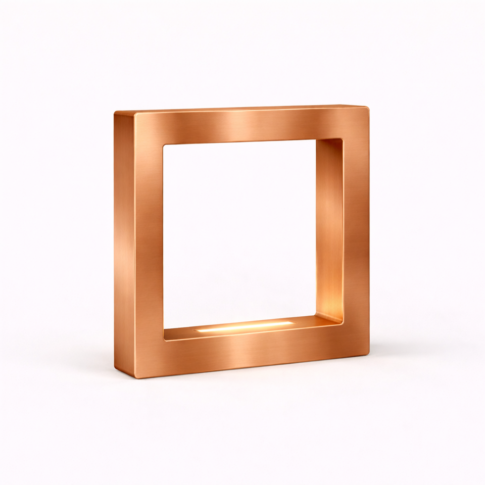 Copper finish square table lamp by WOOM, with brushed metallic texture and a soft glow inside.