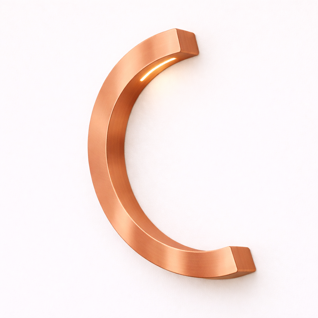 Copper finish C-curved desk lamp by WOOM, mounted on a white wall, with warm light emanating.