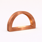 Brushed copper finish arc-curved desk lamp by WOOM, with an integrated strip light.
