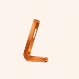L-shaped wooden lamp with a copper finish by WOOM, featuring a glowing vertical light and rounded design.