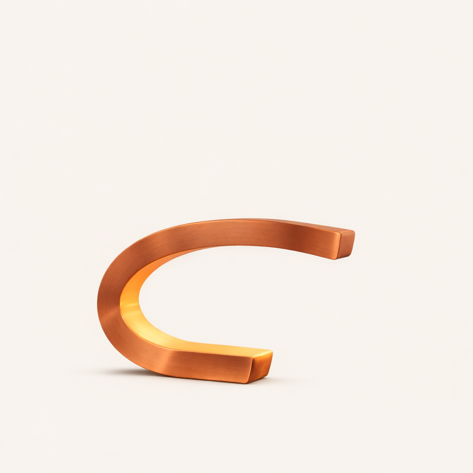 Copper finish C-shaped curved wood lamp by WOOM, glowing warmly from within on a light background.