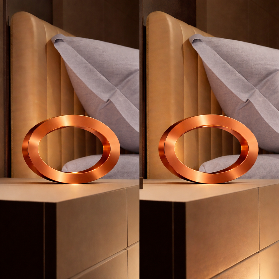 Copper finish oak oval lamp by WOOM on a dark bedside table next to a brown leather headboard.