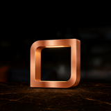 Copper finish square LED lamp by WOOM with rounded corners and an internal light, on a dark marble table.